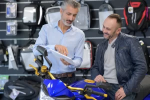 A man at a motorcycle dealership looking at the appraisal on his old motorcycle he wants to trade on a new model with finance