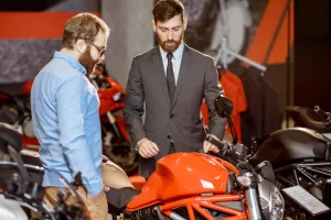 A customer is discussing his new motorcycle purchase with the sales person at the showroom after checking his finance options with Jade Bike Loans